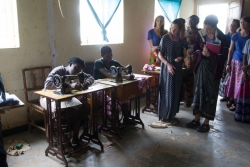 Students visit a community-based organization's tailoring shop where women are taught how to sew in hopes they will learn the trade.