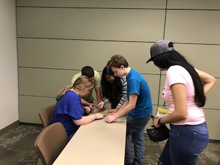 Upward Bound students complete a puzzle of the Colombian flag, while supervised by Fulbright TEA participant Pamela